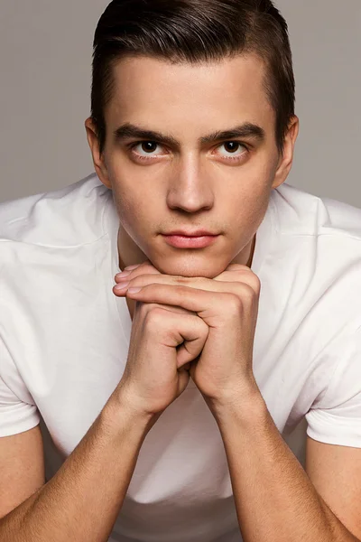 Modelo masculino sentado no estúdio retrato de uma camiseta — Fotografia de Stock