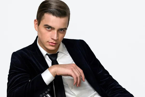 Manlig modell sitter i en business suit svart studio — Stockfoto