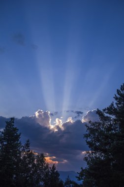 Dağlarda bulutların arkasındaki güneş