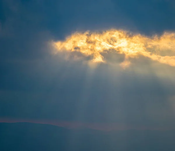 The sun 's rays Breaking through the clouds — стоковое фото