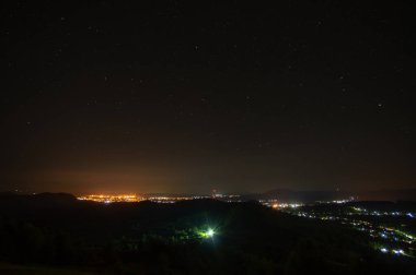 Dağdan alınan küçük bir gece şehrinin manzarası