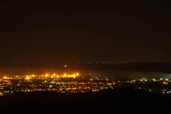 山から撮影された小さな夜の街のパノラマ — ストック写真