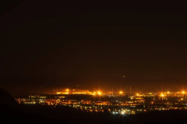 山から撮影された小さな夜の街のパノラマ — ストック写真