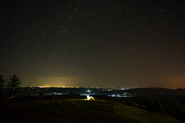 Panorama van een kleine nachtelijke stad genomen van de berg — Stockfoto