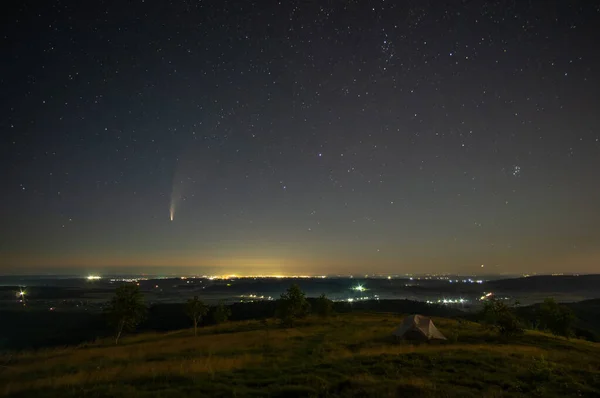 Tienda en las montañas sobre el fondo del cielo estrellado y el cometa — Foto de Stock
