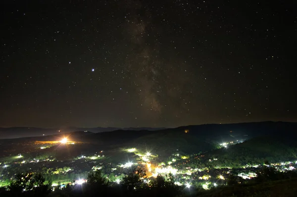 Panorama van het dorp tegen de achtergrond van de Melkweg in de bergen — Stockfoto