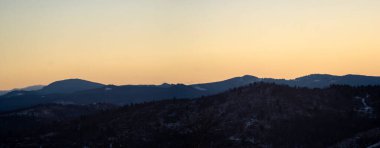 Günbatımının arka planında Karpat dağlarının ve ormanın siluetinin manzarası