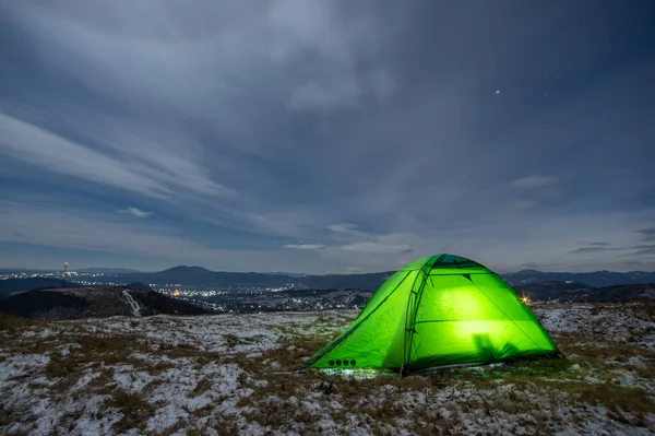 Tent in winter on a mountain top at night in the Carpathians