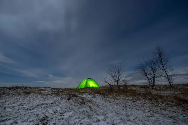 Tent in winter on a mountain top at night in the Carpathians
