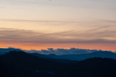 Ukrayna Karpatları 'nda günbatımında tepelerin ve ormanların silueti