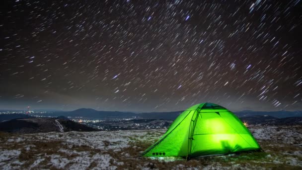 Star trails in winter at night over a tent on a mountain top — Stock Video