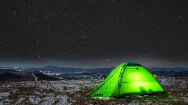 Kışın yıldızların izleri bir dağın tepesindeki çadırın üzerindedir. — Stok video