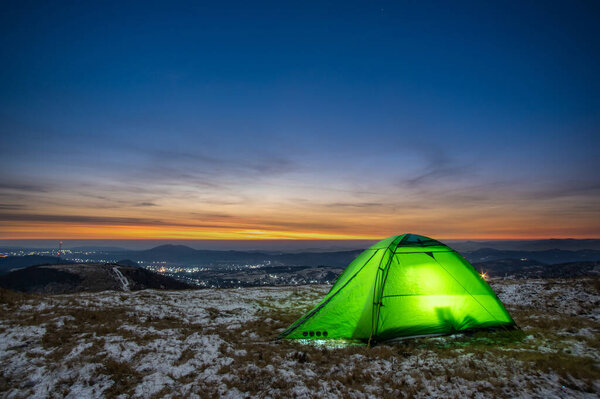Tent on the background of the sunrise in winter in the Carpathian mountains