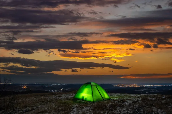 在日落的背景下 帐篷在山顶上 图库图片