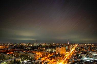 Gece şehrin ışıkları Ukrayna 'daki yıldızlı gökyüzünün arka planına karşı.