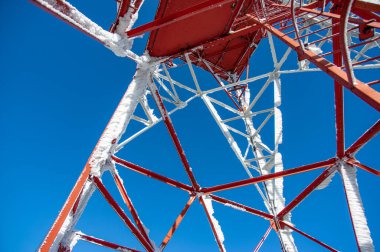 Karpat dağlarında mavi gökyüzüne karşı antenleri olan kule.