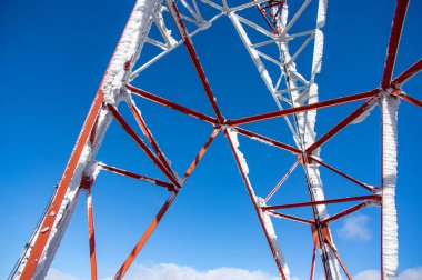 Karpat dağlarında mavi gökyüzüne karşı antenleri olan kule.