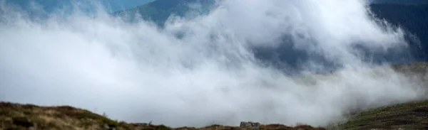 The fog rises over the mountains after the rain in the Carpathians