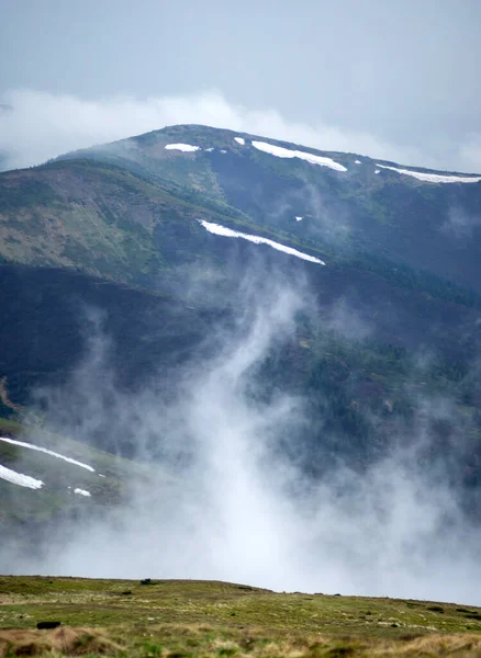 The fog rises over the mountains after the rain in the Carpathians