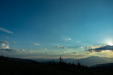 Güneş ışınları ve güzel gökyüzü gün batımında Karpatya dağlarında. Masaüstü ekran koruyucu