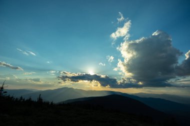 Güneş ışınları ve güzel gökyüzü gün batımında Karpatya dağlarında. Masaüstü ekran koruyucu