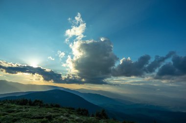 Güneş ışınları ve güzel gökyüzü gün batımında Karpatya dağlarında. Masaüstü ekran koruyucu