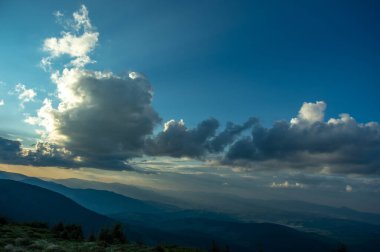 Güneş ışınları ve gün batımında güzel bir gökyüzü Ukrayna Karpatlarının bir dağ köyünde. Masaüstü ekran koruyucu