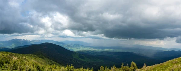 Panorama of the Carpathian mountains during rain, storm clouds and rain in summer, vacation and travel in the mountains, beautiful landscape