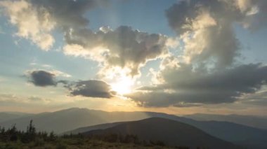 Günbatımında Ukrayna 'daki Karpat dağlarında güzel 4k hızlandırılmış güneş ışınları ve bulutlar.