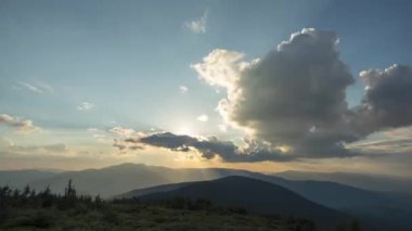 Günbatımında Ukrayna 'daki Karpat dağlarında güzel 4k hızlandırılmış güneş ışınları ve bulutlar.