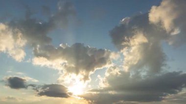 Güneş ışınları ve bulutlar gün batımında gökyüzünde, 4k zaman atlaması
