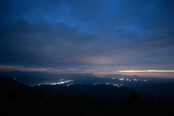 Dawn sky over the village in the Ukrainian Carpathians. Rest and travel in the mountains. Night landscape