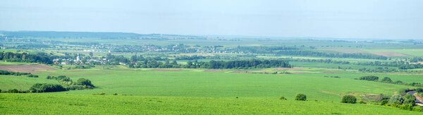 Beautiful panorama of agricultural fields and hills on a summer day