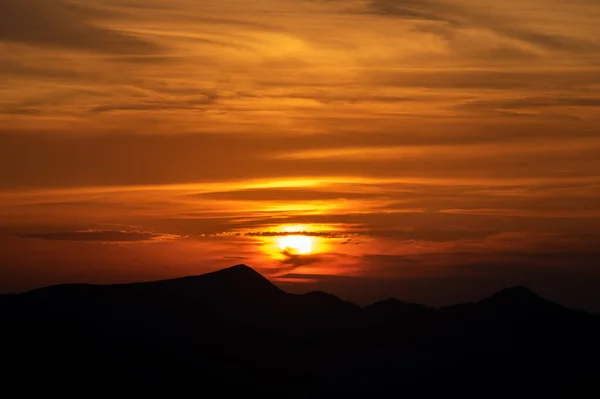 夏日落山时山的轮廓 免版税图库照片