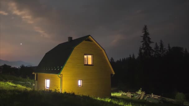 Dom w górach na tle gwiaździstego nieba i księżyca — Wideo stockowe