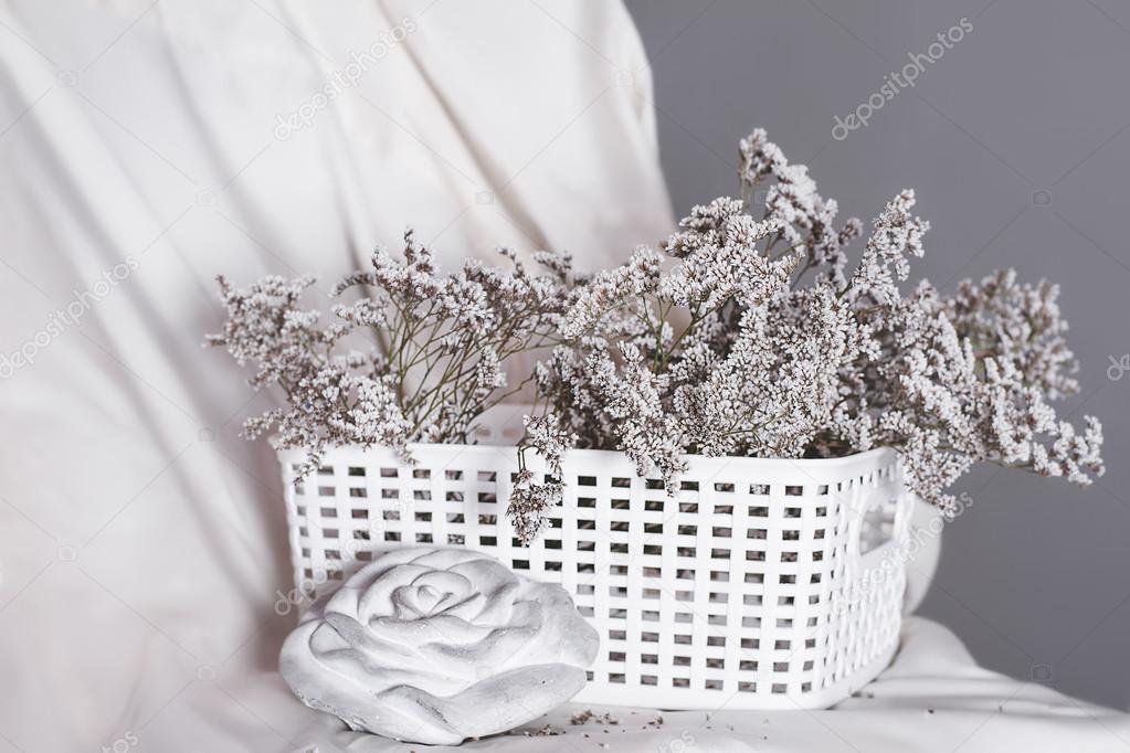 basket with flowers next to a rose