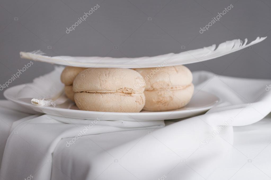 light double biscuit with a feather on top of the saucer