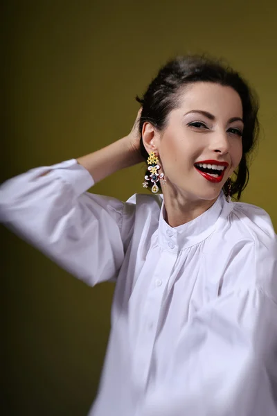 Menina morena em uma camisa branca estrita e brincos — Fotografia de Stock