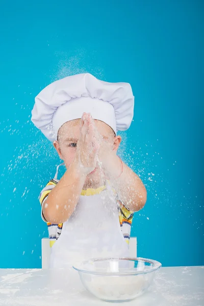 the young chef, claps his hands in flour