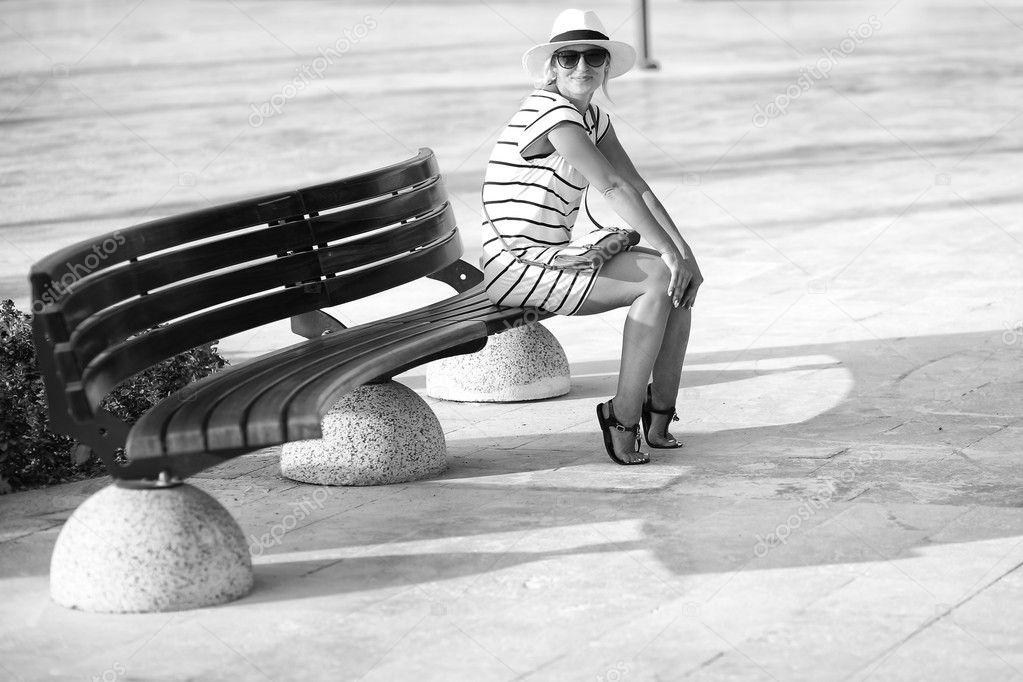 girl in a striped dress sitting on bench