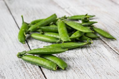 Yeşil bezelye Pod bir beyaz ahşap tablo