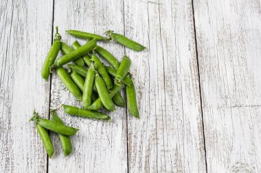 Yeşil bezelye Pod bir beyaz ahşap tablo