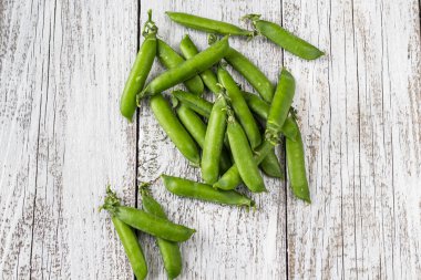 Yeşil bezelye Pod bir beyaz ahşap tablo