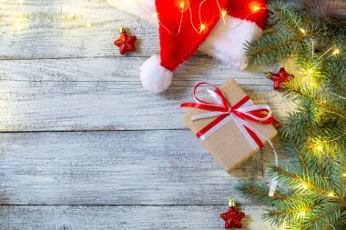 Noel ağacı süslemesi Noel Baba şapkası ve hediyeleriyle birlikte yatıyordu. Çiçekli yeni yıl manzarası