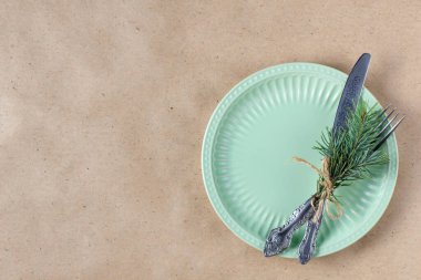 Noel ağacının dalları, boş tabaklar ve süslemelerle dolu bir tatil masası. Yeni yıl düz gıda konsepti zanaat geçmişi üzerine