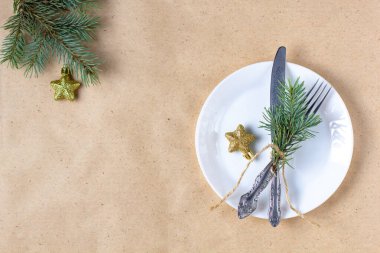 Noel ağacının dalları, boş tabaklar ve süslemelerle dolu bir tatil masası. Yeni yıl düz gıda konsepti zanaat geçmişi üzerine