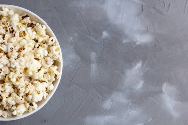 Gri masada beyaz kasede patlamış mısır. Kopyalama alanı olan üst görünüm