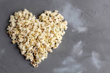 Gri taşlı arka planda kalp şeklinde patlamış mısır. Aşk filmi. en üstteki görünüm.