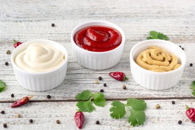 Beyaz ahşap arka planda baharatlı çeşitli soslar. Mayonez ketçap hardalı. en üstteki görünüm