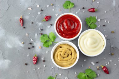 Gri taş arka planda baharatlı çeşitli soslar. Mayonez ketçap hardalı. Kopyalama alanı olan üst görünüm